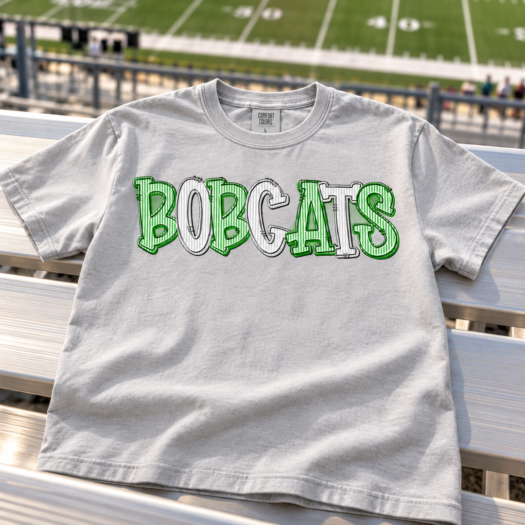 Personalized Bobcats DTF transfer design pressed on a gray Comfort Colors tee, shown on stadium bleachers