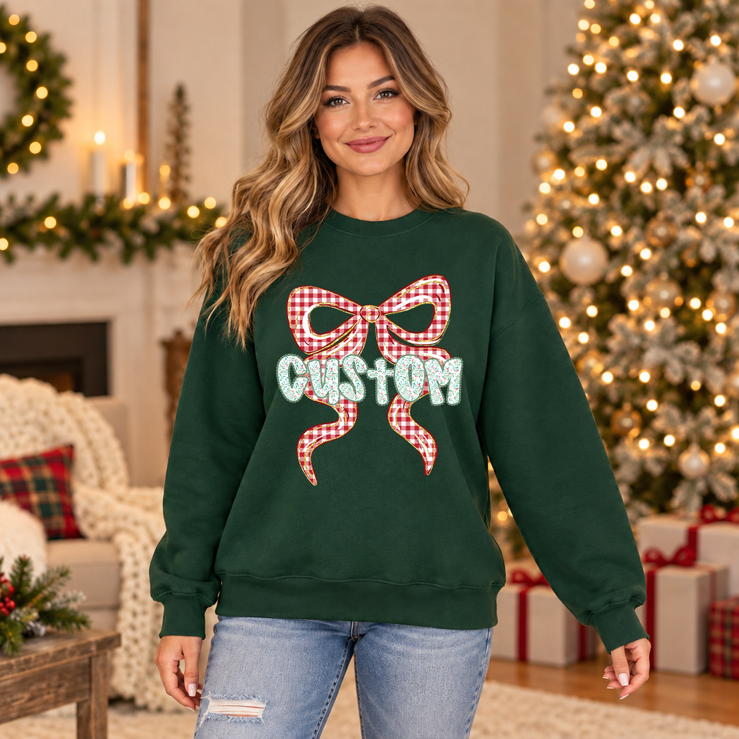 Plaid Bow Custom Word DTF transfer mockup on a green sweatshirt, custom word across a red gingham bow