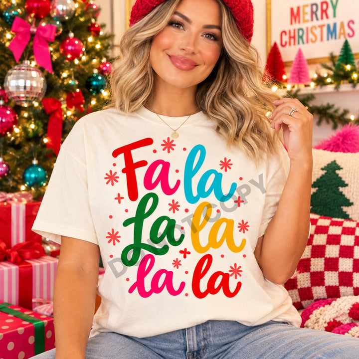 Fa La La La La colorful script Christmas DTF transfer mockup on a cream tee