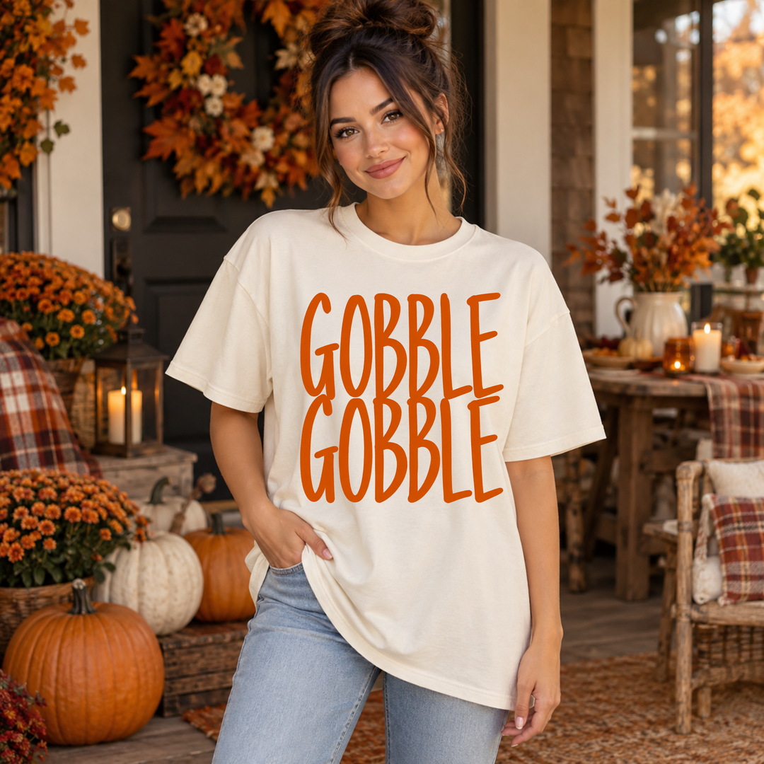 Gobble Gobble orange block letter Thanksgiving DTF transfer mockup on a cream tee