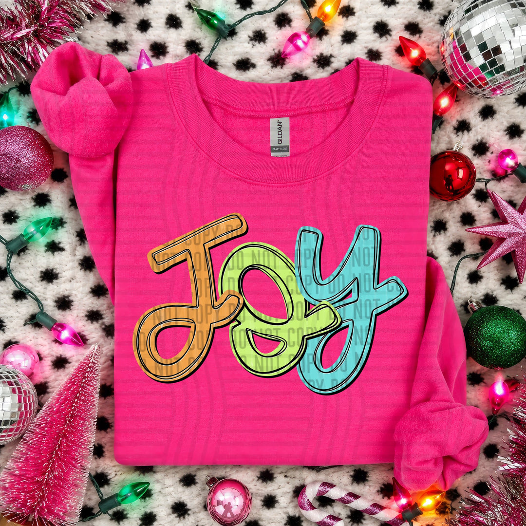 Joy Script Christmas DTF transfer shown on a pink sweater