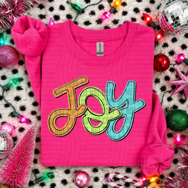Joy Script Christmas DTF transfer shown on a pink sweater