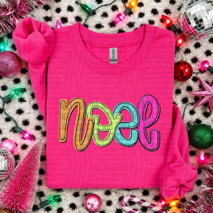 Noel Script Christmas DTF transfer shown on a pink sweater