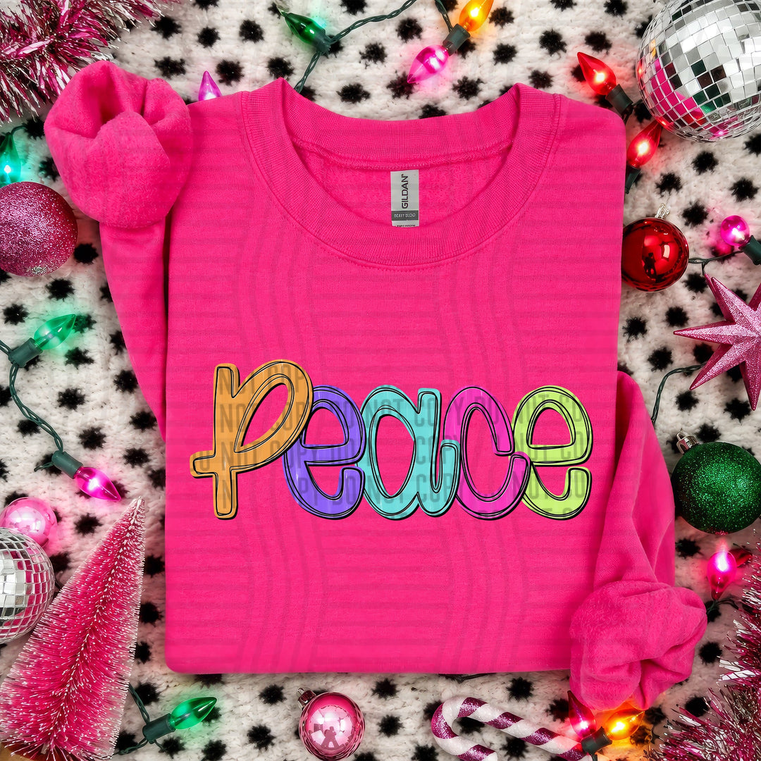 Peace Script Christmas DTF transfer shown on a pink sweater