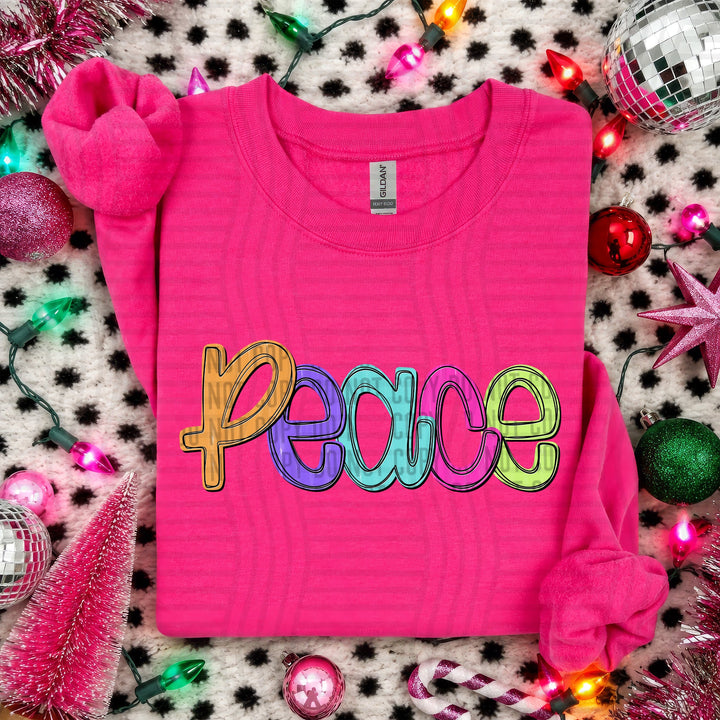 Peace Script Christmas DTF transfer shown on a pink sweater